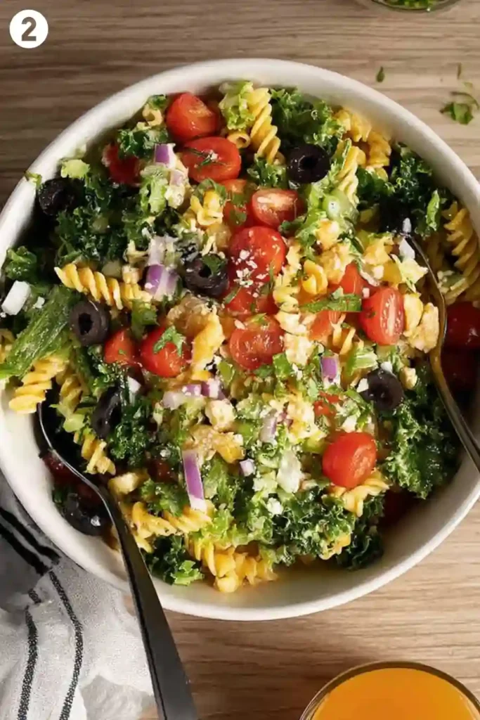 Tossing High Protein Pasta Salad with Dressing and Fresh Ingredients