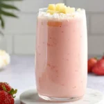 Refreshing Bahama Mama tropical smoothie topped with pineapple and coconut flakes