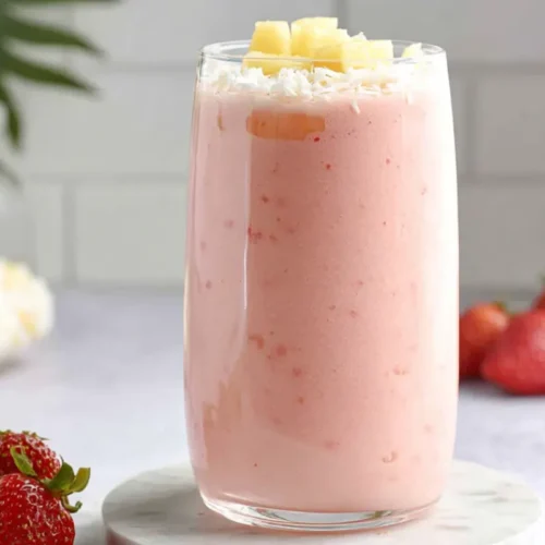 Refreshing Bahama Mama tropical smoothie topped with pineapple and coconut flakes