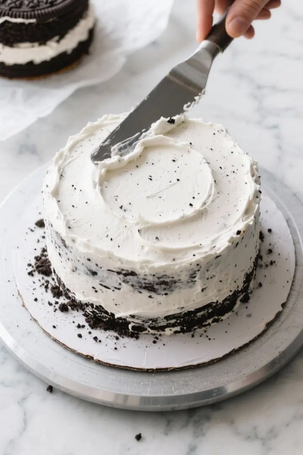 Cooking process: Overhead shot of the first cake layer on a turntable during assembly, showing a gen