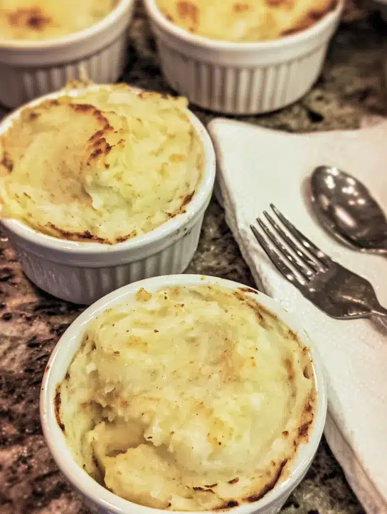 Reheated leftover mashed potato casserole served in small bowls.