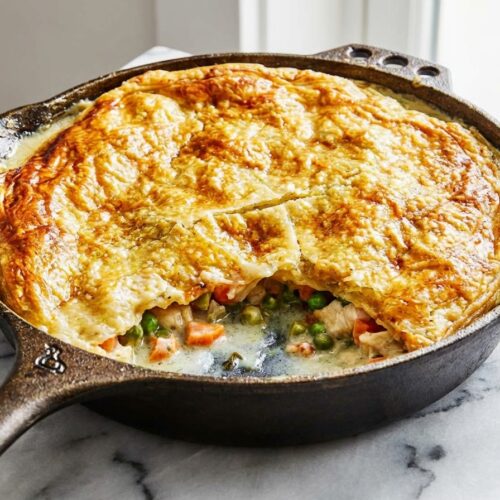 Golden brown Chicken Pot Pie Recipe with a flaky puff pastry crust, showcasing a rich filling enhanced by brown butter and white wine deglazing.