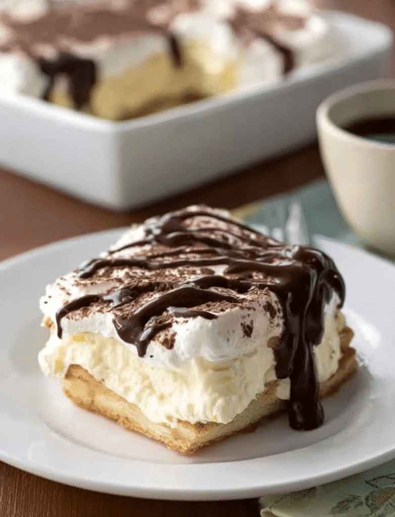 A beautifully arranged slice of Chocolate Eclair Cake on a plate, ready to be served at a casual gathering.