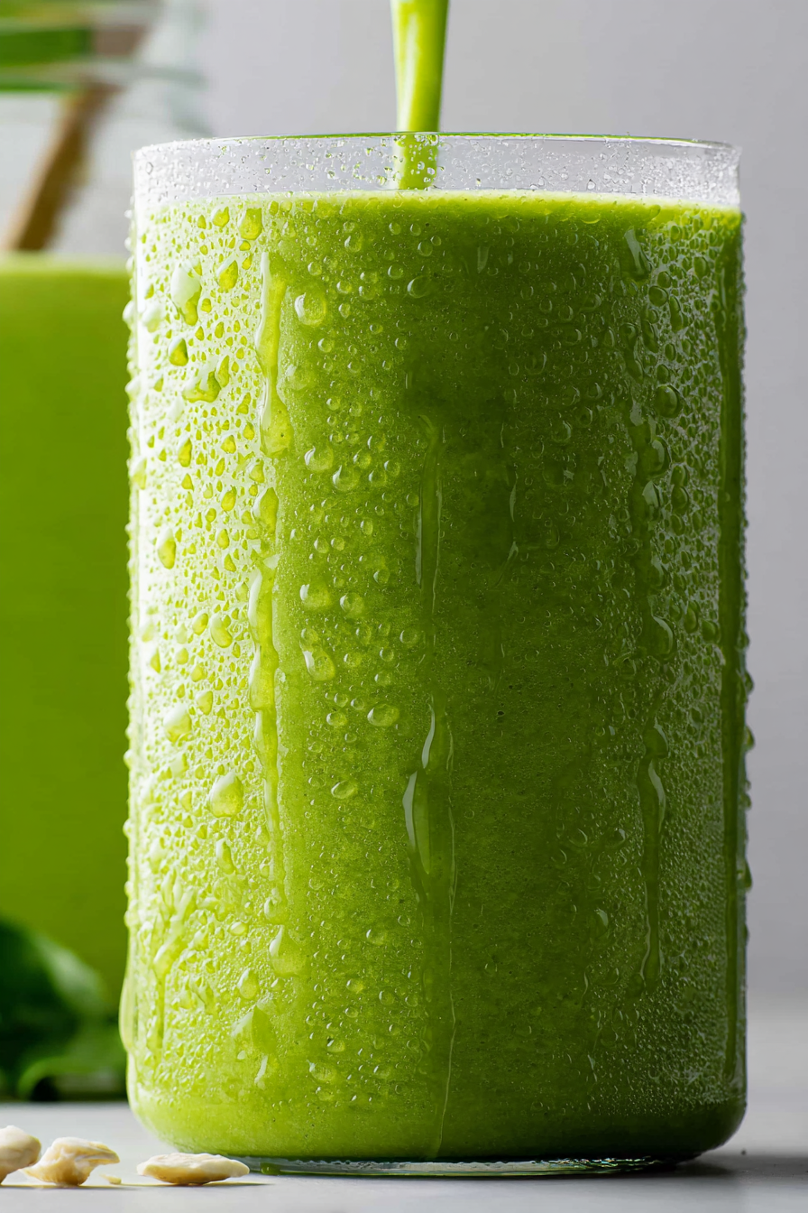 A close-up view of the smooth, vibrant green texture of the Detox Island Green Smoothie, showcasing its creamy consistency.