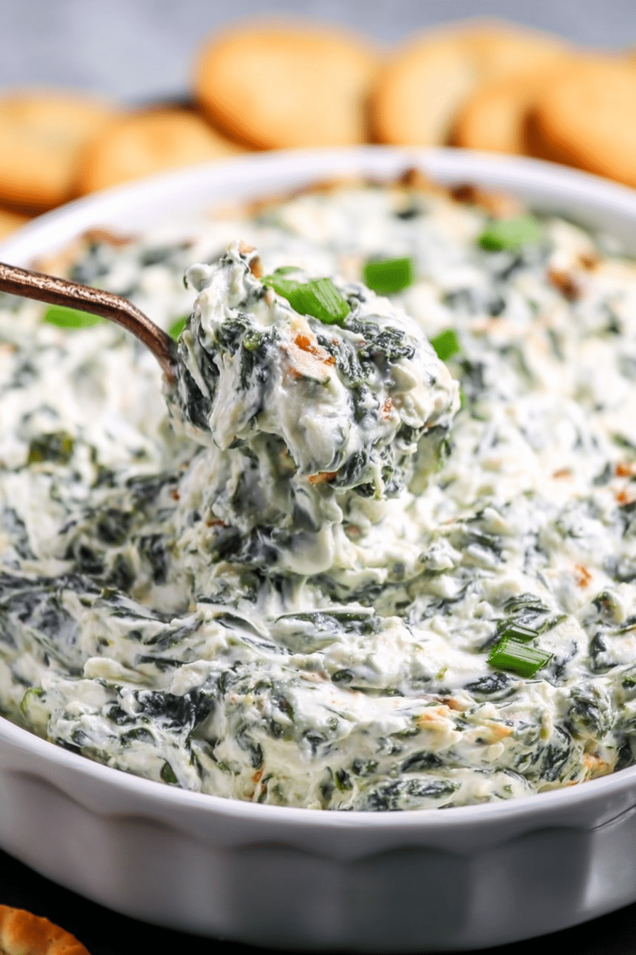 Close-up of creamy Knorr Spinach Dip texture, showing chopped spinach, water chestnuts, and a smooth, thick consistency, ready for scooping.