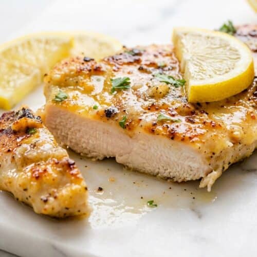 Golden-brown lemon chicken recipe cutlets glistening with a rich, velvety monter au beurre pan sauce, garnished with fresh parsley.