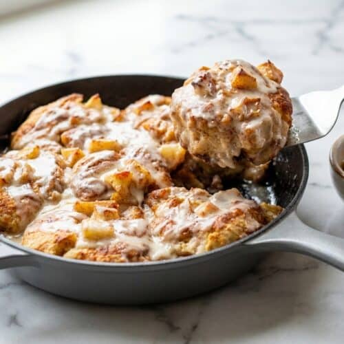 Golden apple pie biscuits in a cast iron skillet with salted maple glaze and brown butter.