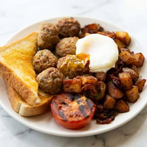 Glazed breakfast meatballs with a sticky Maple-Dijon finish on a white serving platter.
