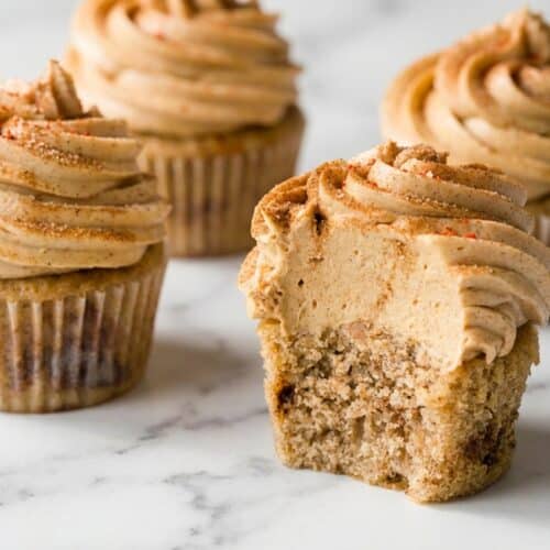 Frosted churro cupcakes with spiced chocolate garnish and golden brown butter buttercream swirls.