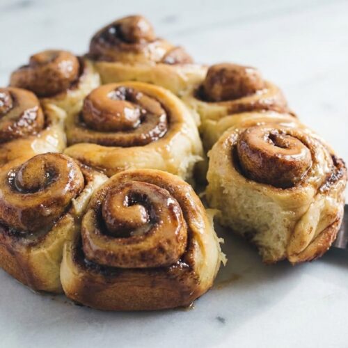 Gooey sourdough cinnamon rolls soaked in heavy cream and brown butter in a springform pan.