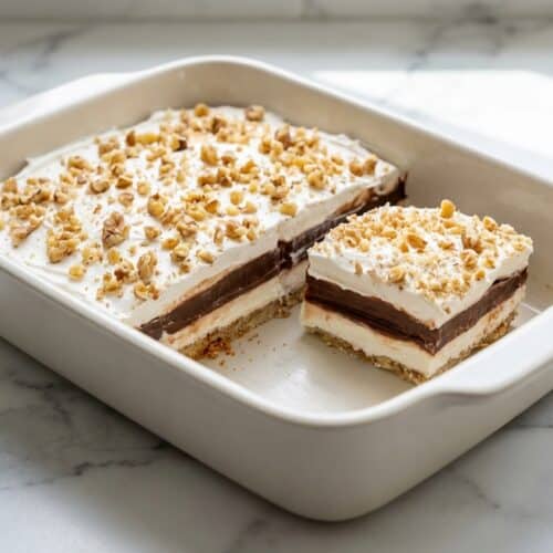 Sliced four layer delight with a nutty browned butter shortbread crust and creamy whipped topping.