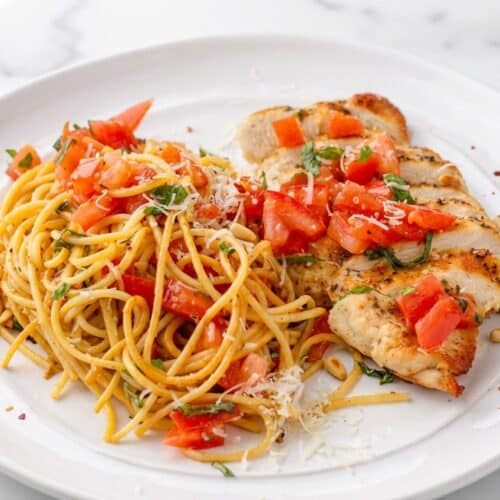 Bruschetta chicken pasta topped with toasted pine nuts, chiffonade basil, and a sprinkle of spicy Aleppo pepper.