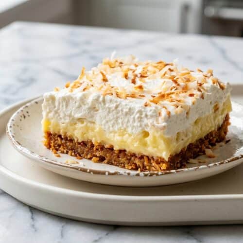 Creamy coconut cream pie bars with a golden brown butter and toasted coconut crust and whipped topping.