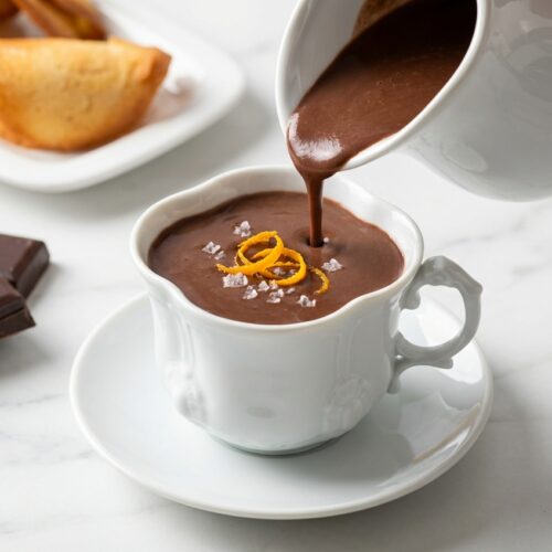 Rich French Hot Chocolate topped with Chantilly cream, fresh orange zest, and a pinch of smoked sea salt.