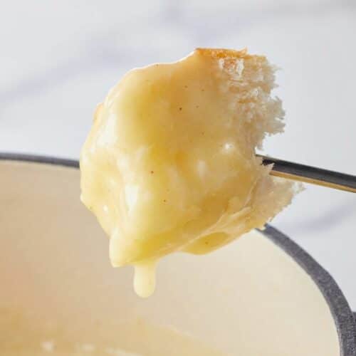 Glossy cheese fondue recipe with a smooth sodium citrate emulsion in a ceramic pot.