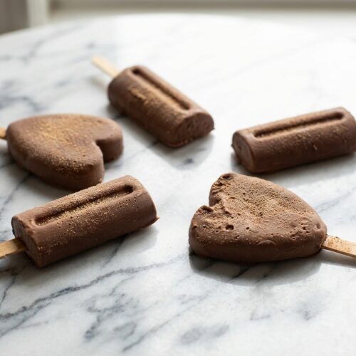 Rich homemade fudge popsicles with a smooth malted milk infusion finish on wooden craft sticks.