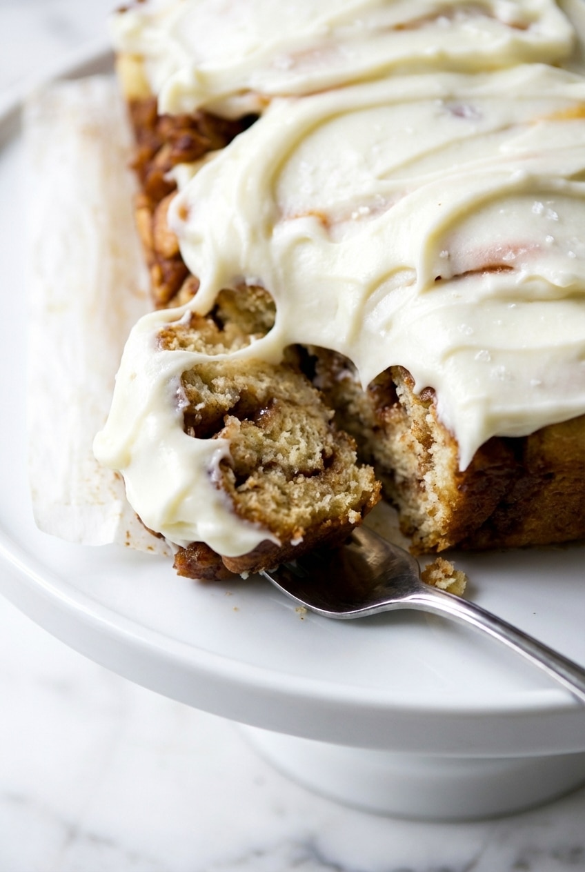 Using a hand mixer to create a smooth emulsification for the perfect cream cheese glaze consistency.
