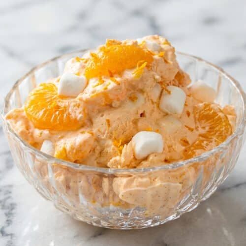 Creamy orange dreamsicle salad featuring a double-vanilla citrus infusion and fresh orange zest in a glass serving bowl.