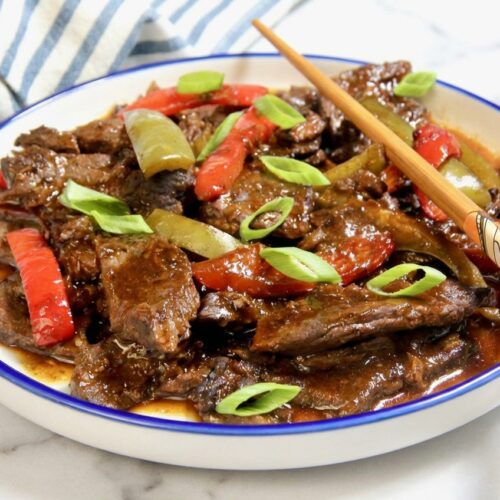Tender velveted pepper steak recipe with colorful bell peppers and a glossy ginger-honey glaze.