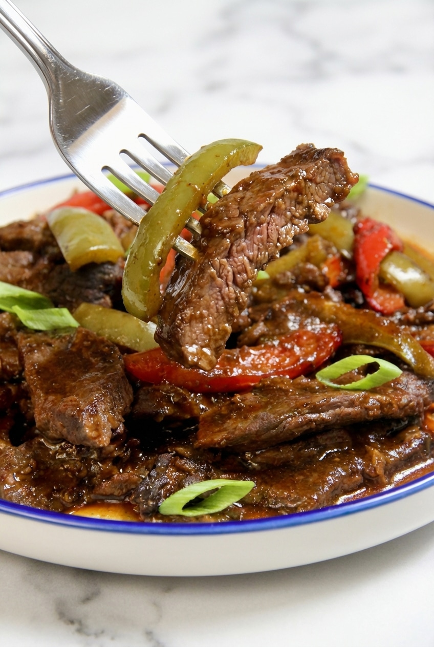 Close-up of silky beef strips from this pepper steak recipe highlighting the tender velveting meat technique.