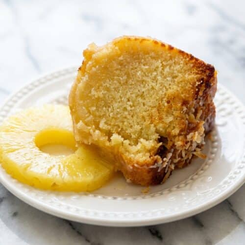 Golden pina colada pound cake in a Bundt pan drenched in a glossy pineapple-rum glaze soak.
