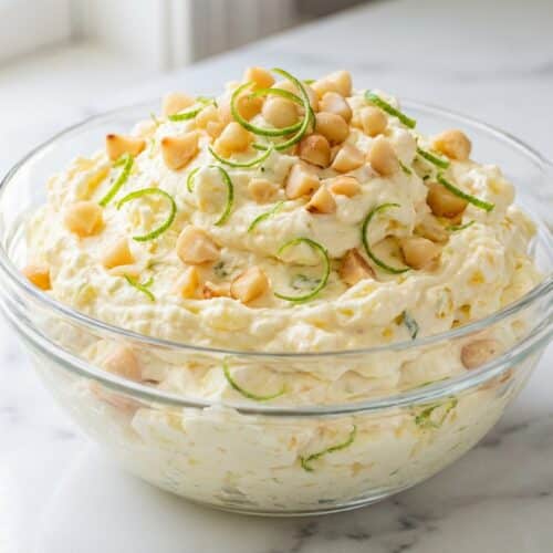 Creamy pineapple fluff dessert topped with crunchy toasted macadamias and fresh lime zest.
