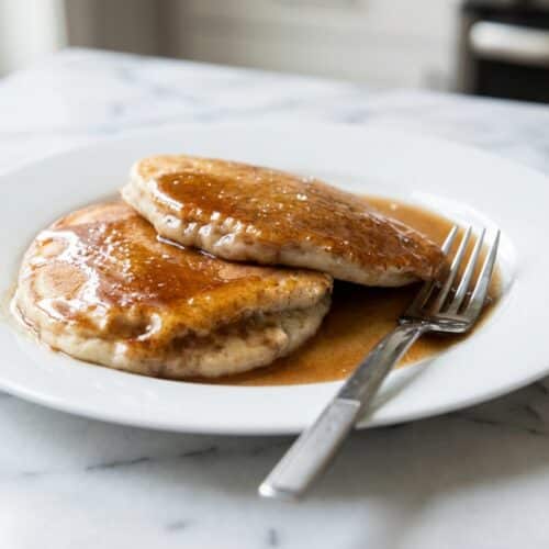 Thick salted brown butter cinnamon pancake syrup drizzled slowly over a warm stack of breakfast flapjacks.
