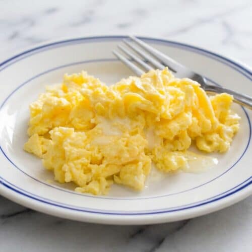 Creamy scrambled eggs prepared using the cold butter emulsion technique for a velvety texture.