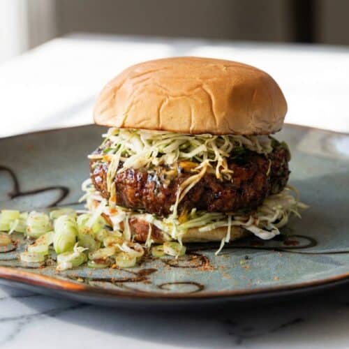 Teriyaki burger topped with melting charred pineapple-miso compound butter on a toasted bun.