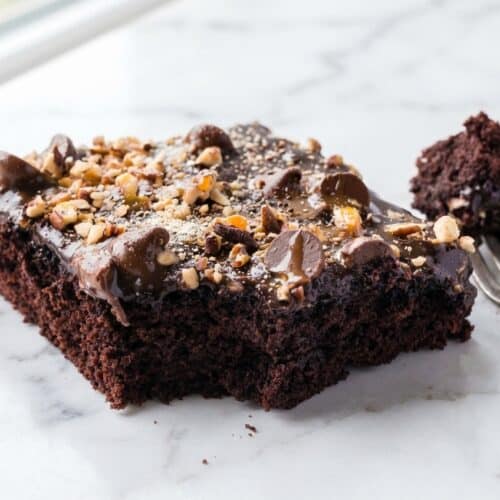 Texas turtle sheet cake with malted milk chocolate frosting and toasted pecans on a half sheet pan.