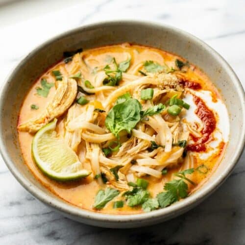 Creamy Thai chicken curry soup featuring a rich broth made by blooming red curry paste in coconut cream.