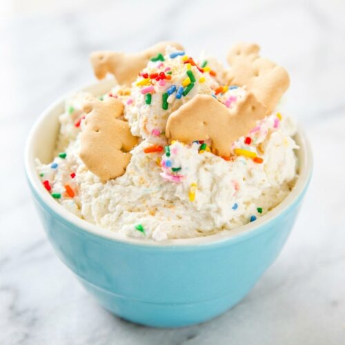 Creamy Funfetti Dip topped with rainbow jimmies featuring a unique toasted malt flavor profile.