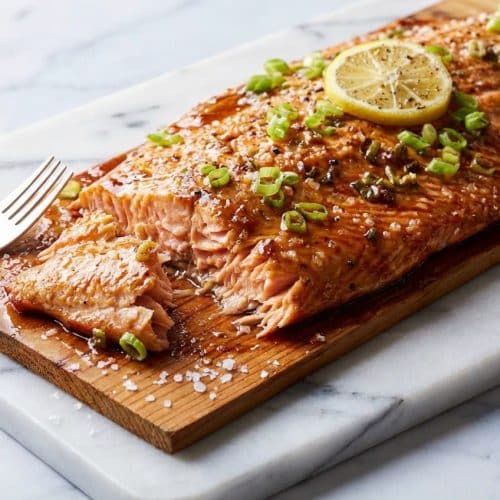 Tender cedar plank salmon featuring a bourbon and sea salt infusion for a deep, smoky flavor profile.