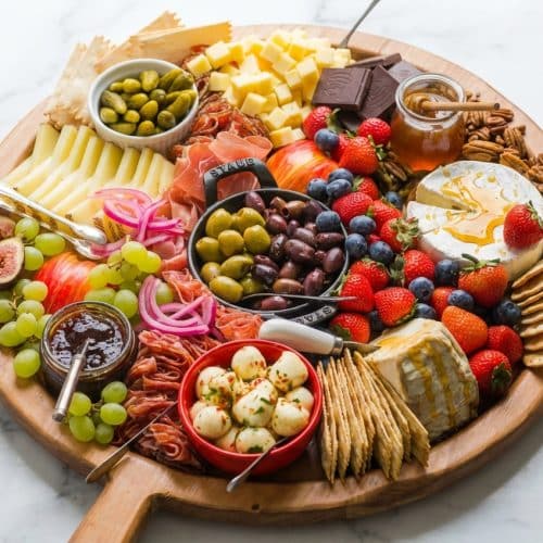 Gourmet charcuterie board featuring cured meats, artisan cheeses, quick-pickled red onions, and a hot honey infusion.