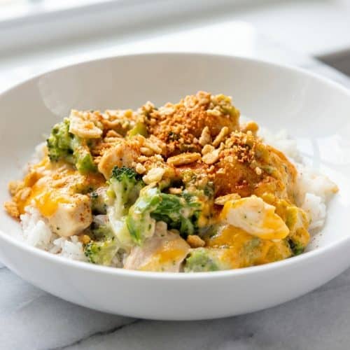 Creamy chicken divan recipe topped with a golden smoked paprika and Ritz cracker crunch in a ceramic baking dish.