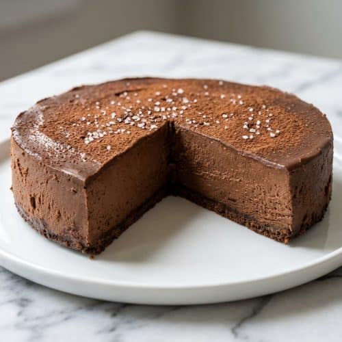 Velvety chocolate mousse cheesecake topped with a dark espresso-salted cocoa bloom glaze.