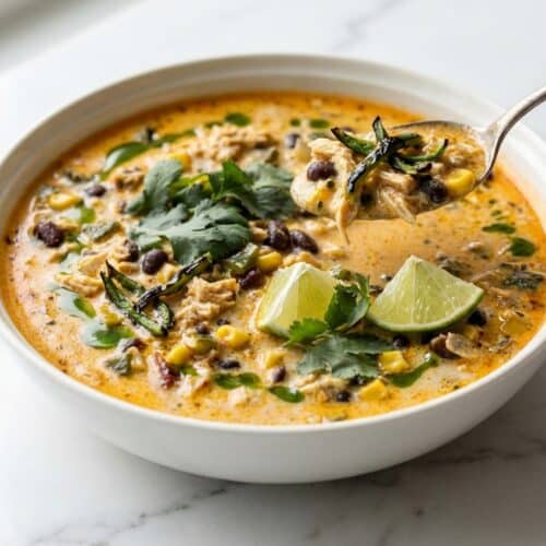Creamy chicken poblano soup topped with tortilla strips, showcasing the double-poblano depth technique.