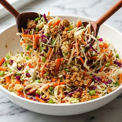 Vibrant Crunchy Asian Salad bowl topped with brown butter and soy granola, Napa cabbage, and edamame.