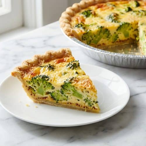 Golden broccoli cheese quiche in a flaky crust with a savory Dijon and Parmesan base layer.