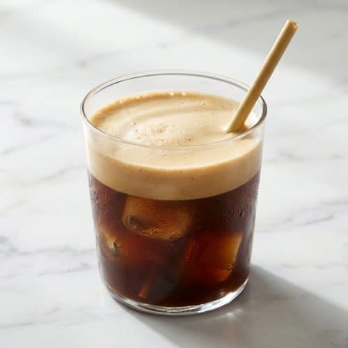 Frothy Freddo Espresso recipe showing the dense crema created by the double-chilled filtration method in a tall glass.