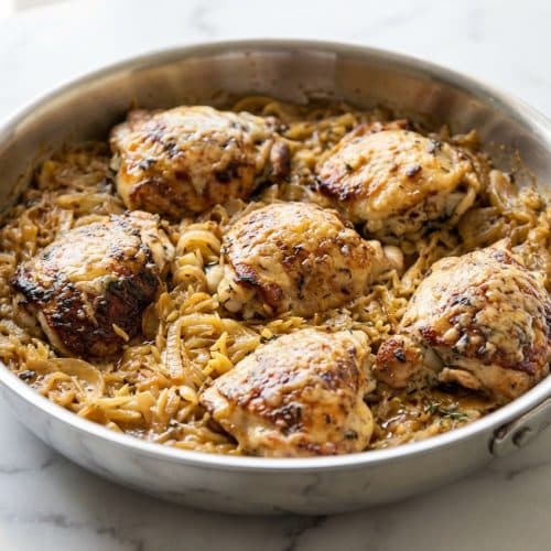 French onion chicken orzo with a bubbling Gruyère crust and rich sherry-deglazed onions in a cast iron skillet.