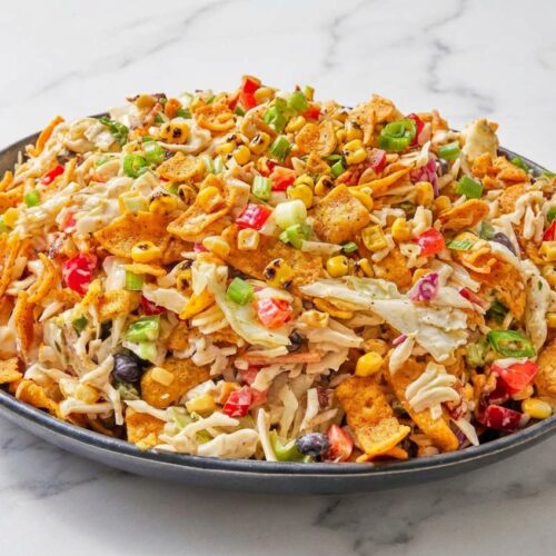 Frito cowboy cabbage topped with smoky skillet-charred corn, crunchy chili cheese chips, and fresh jalapenos.