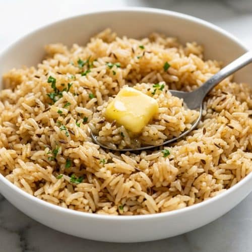 Fluffy Garlic Butter Rice with toasted cumin and nutty brown butter in a ceramic bowl.