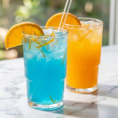 Vibrant blue homemade gatorade in a glass rimmed with a citrus-zest honey maceration for natural sweetness.