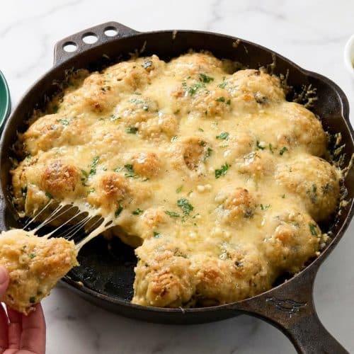 Soft, twisted garlic knots glazed with honey-infused butter and topped with fresh green parsley.