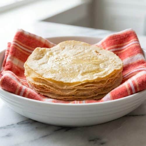 Stack of warm corn tortillas made with a touch of honey for a soft, pliable, and subtly sweet finish.