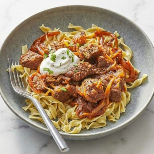 Tender Hungarian Goulash in a rich red wine and caraway sauce served over buttery egg noodles.