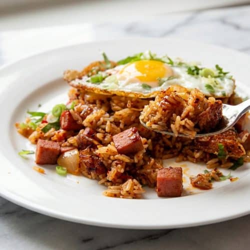 Kimchi fried rice topped with a fried egg and a glossy brown butter gochugaru drizzle.