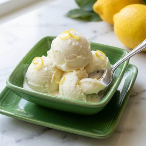 Creamy lemon gelato recipe topped with cold-infused zest and a delicate sprinkle of flaky sea salt in a bowl.