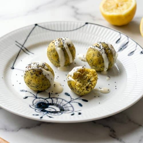Lemon Poppyseed Energy Bites stacked on a plate, featuring toasted poppy seeds and a hint of cardamom.
